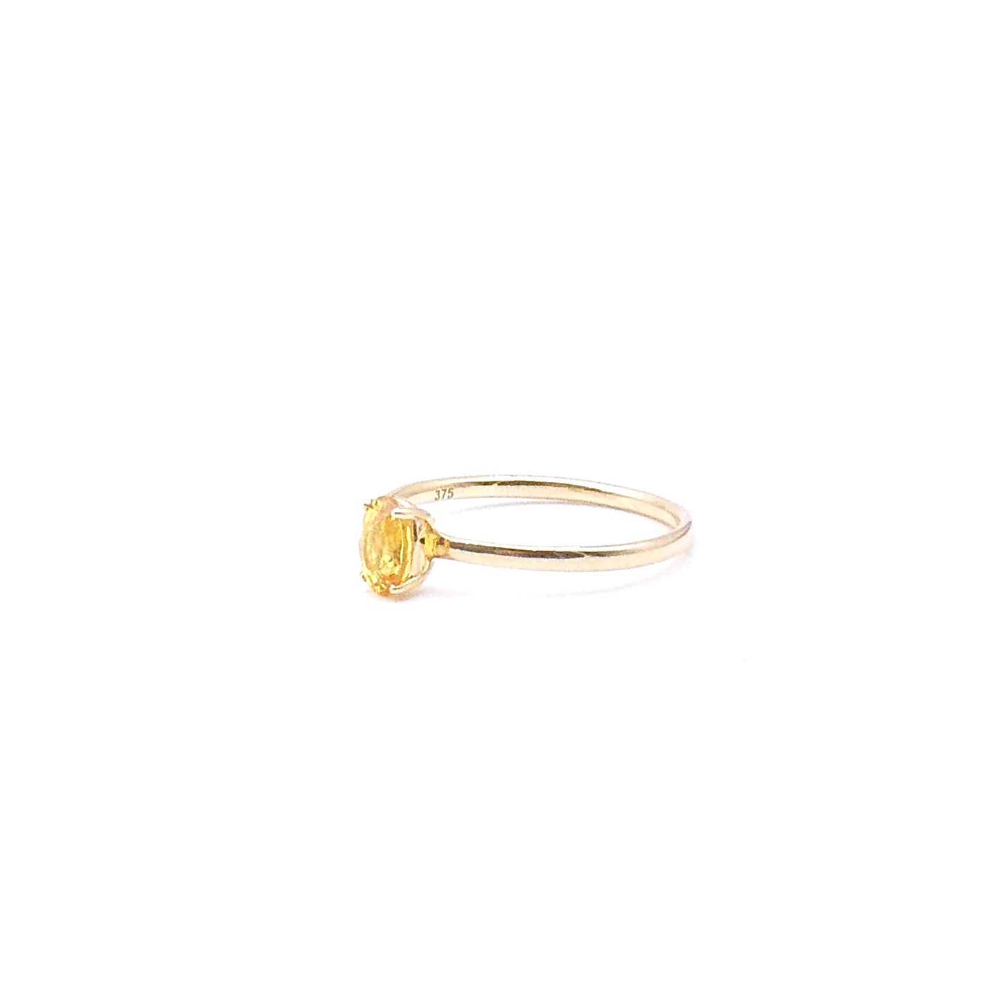 A yellow oval cut Sapphire set in a four claw setting, a fine new 9kt gold ring.