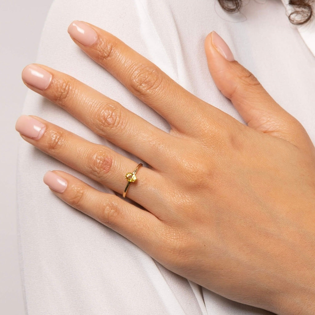 A yellow oval cut Sapphire set in a four claw setting, a fine new 9kt gold ring.