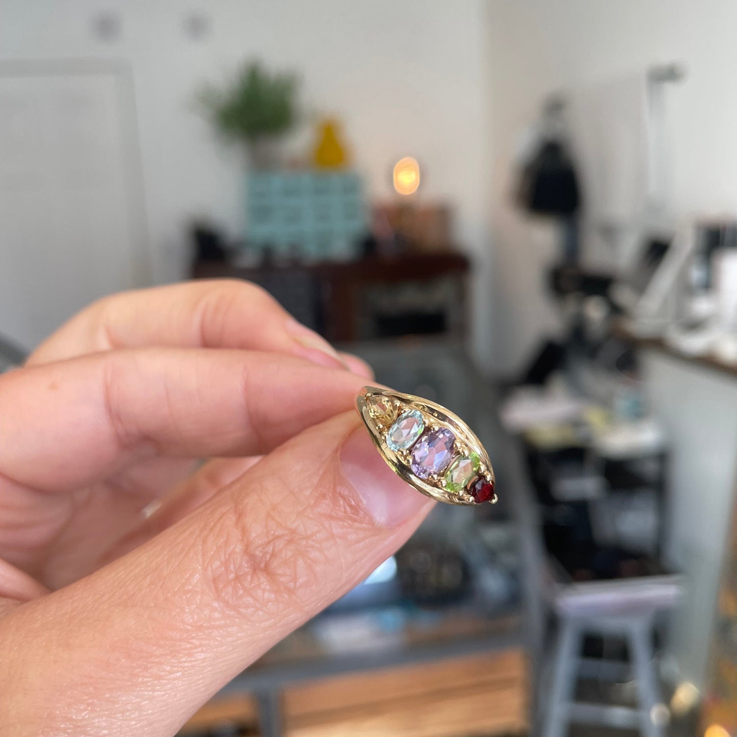 An unusual gold ring set with gemstones framed by the 9kt gold setting,
