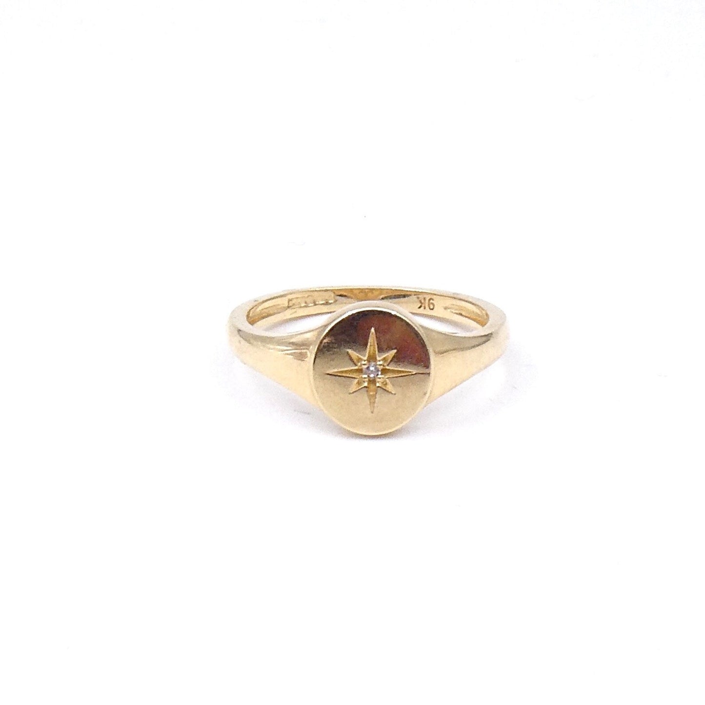 A signet ring engraved with a star, set with a crystal, 9kt gold oval signet ring. - Collected