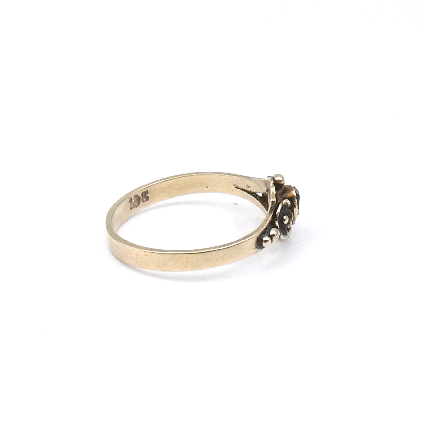 Antique ring with etched flowers and a small rectangular emerald.