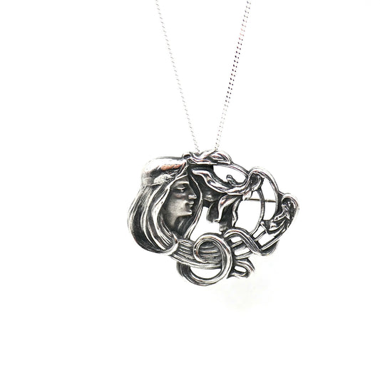 An Art Nouveau style pendant/brooch in sterling silver.