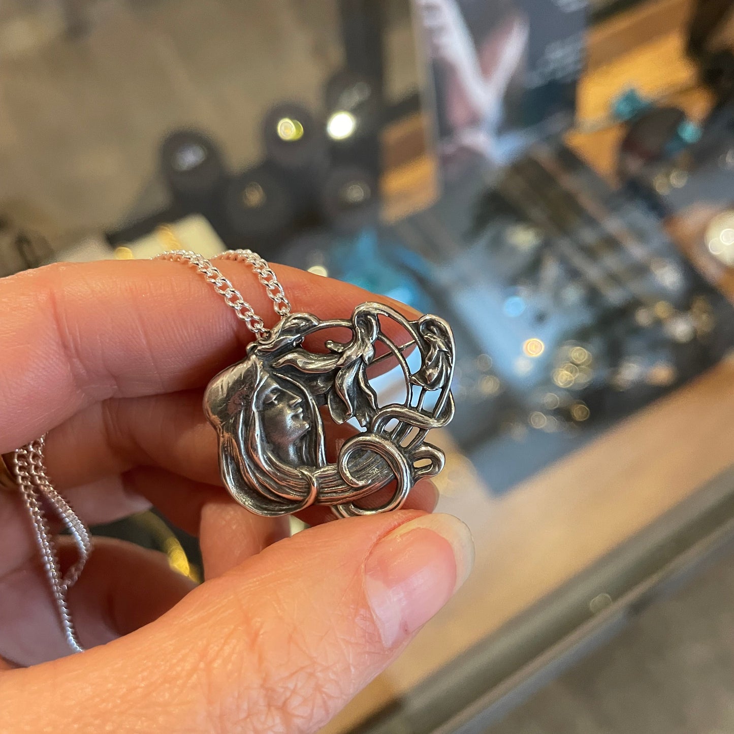 An Art Nouveau style pendant/brooch in sterling silver.