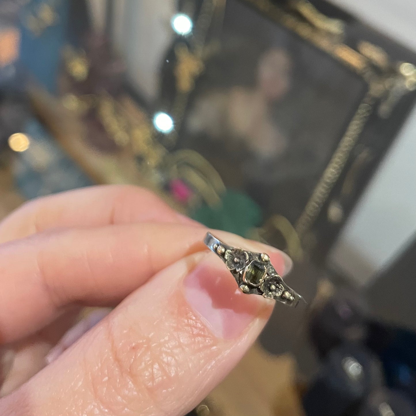 Antique ring with etched flowers and a small rectangular emerald.
