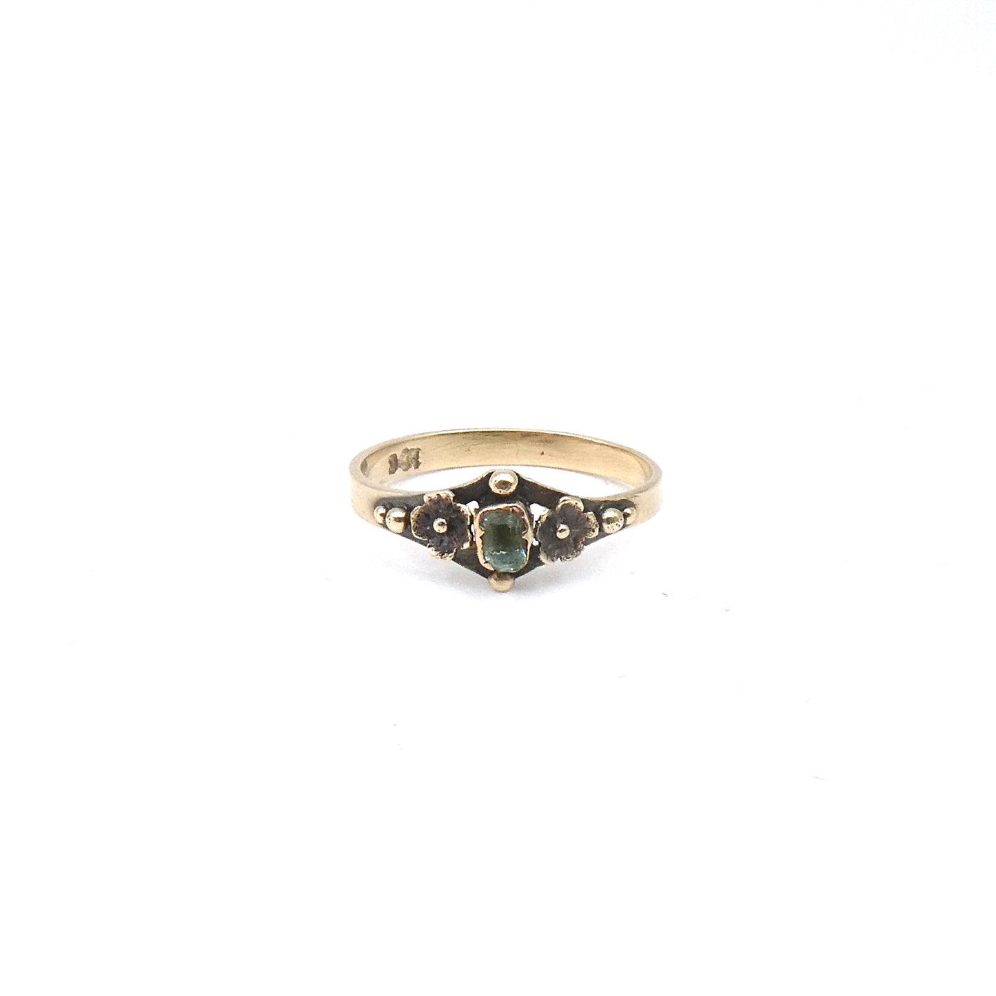 Antique ring with etched flowers and a small rectangular emerald.