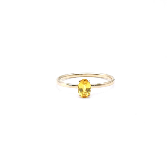 A yellow oval cut Sapphire set in a four claw setting, a fine new 9kt gold ring.