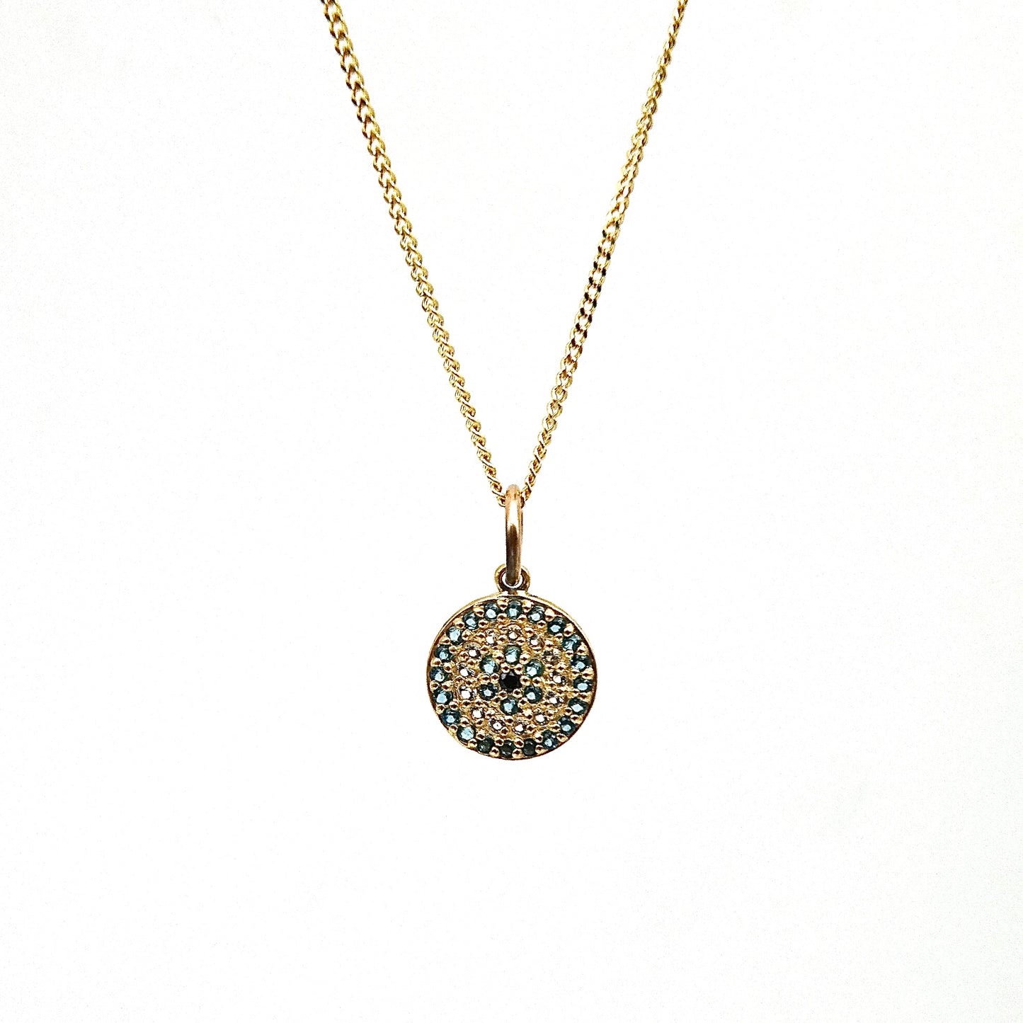 A 9kt gold Evil Eye disc with gemstones.