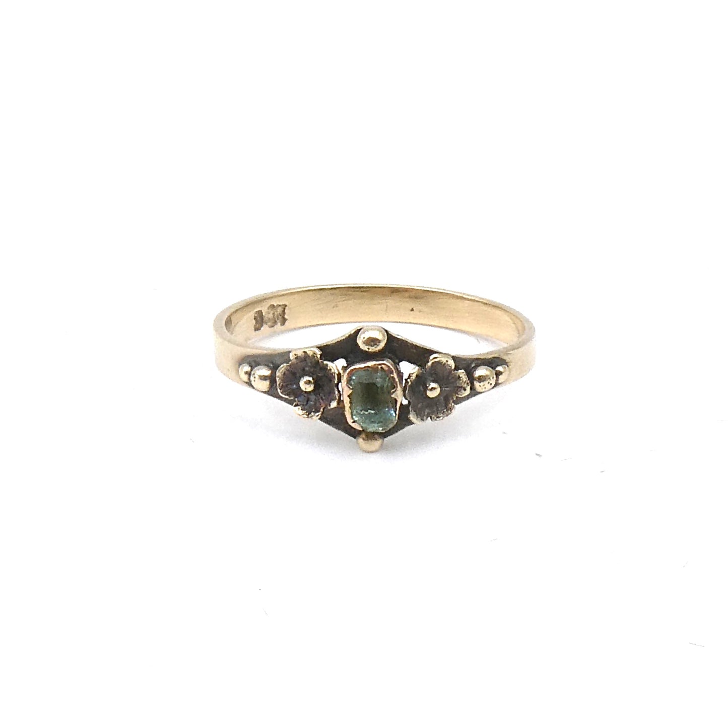 Antique ring with etched flowers and a small rectangular emerald.