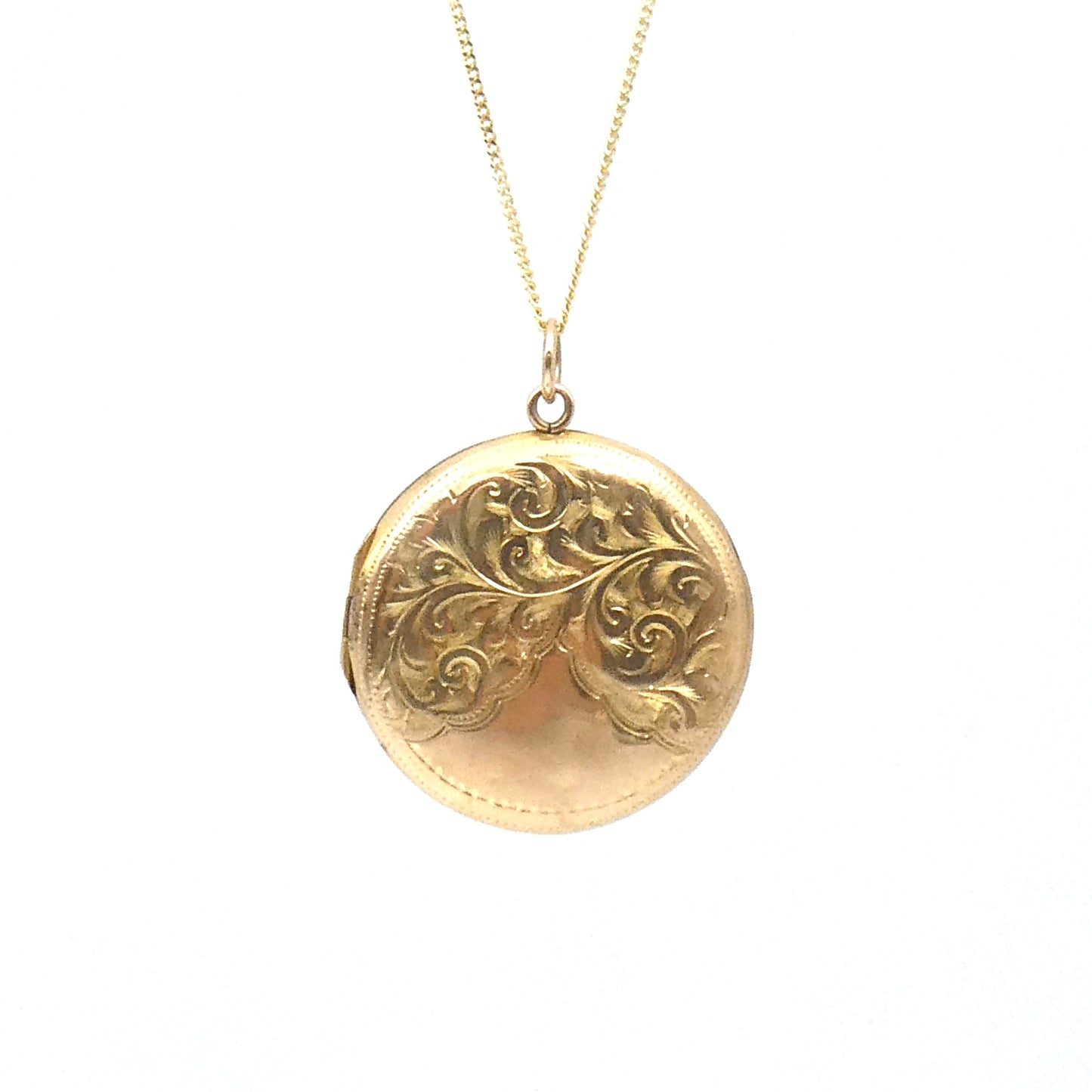Victorian round locket with an elegant scroll motif, on a 9kt gold chain.