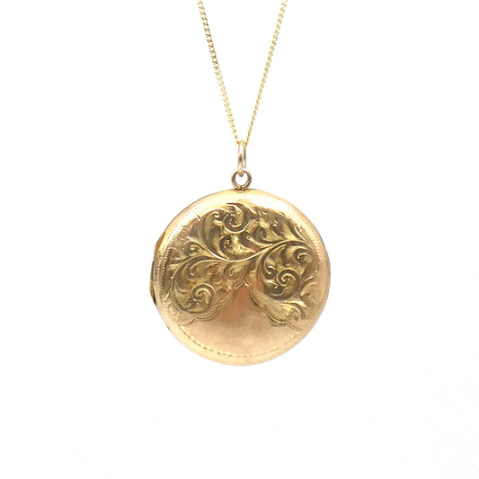Victorian round locket with an elegant scroll motif, on a 9kt gold chain.
