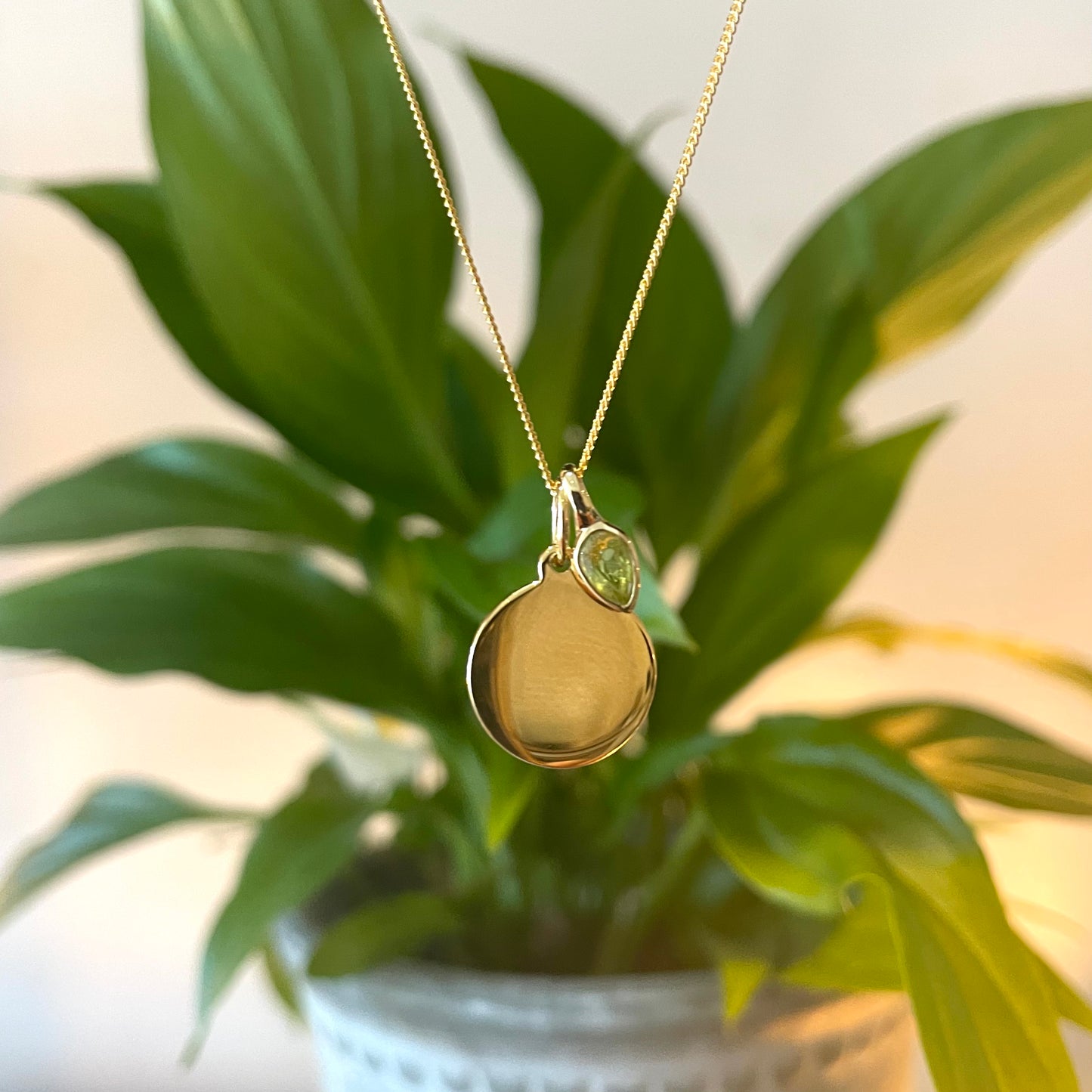 Gold Disc pendant with a peridot charm for an August Birthday.