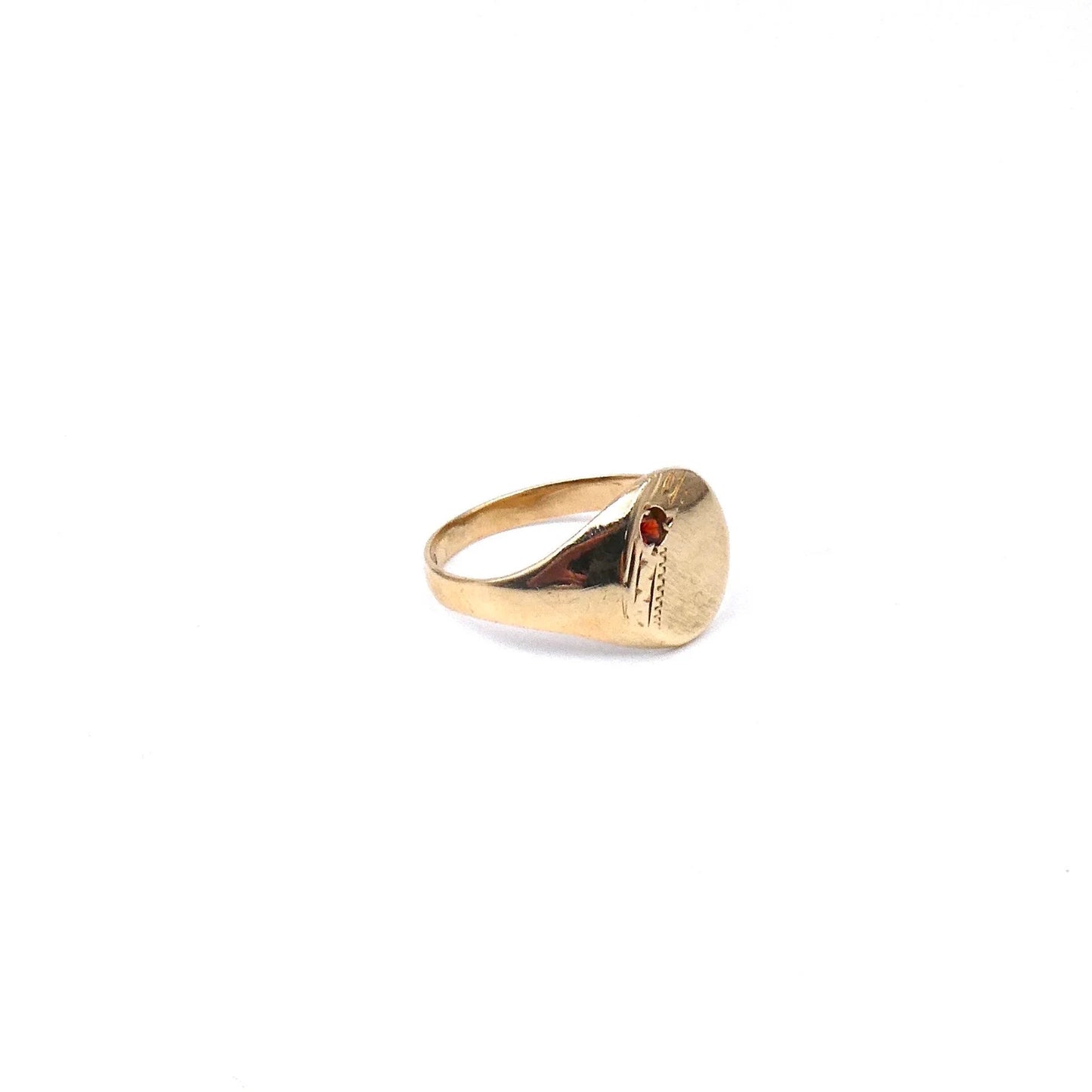 A small oval signet ring set with a garnet with a diagonal engraving.