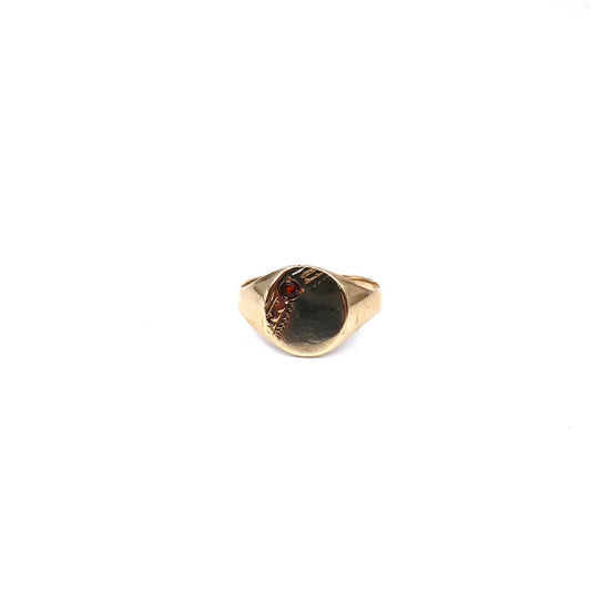 A small oval signet ring set with a garnet with a diagonal engraving.