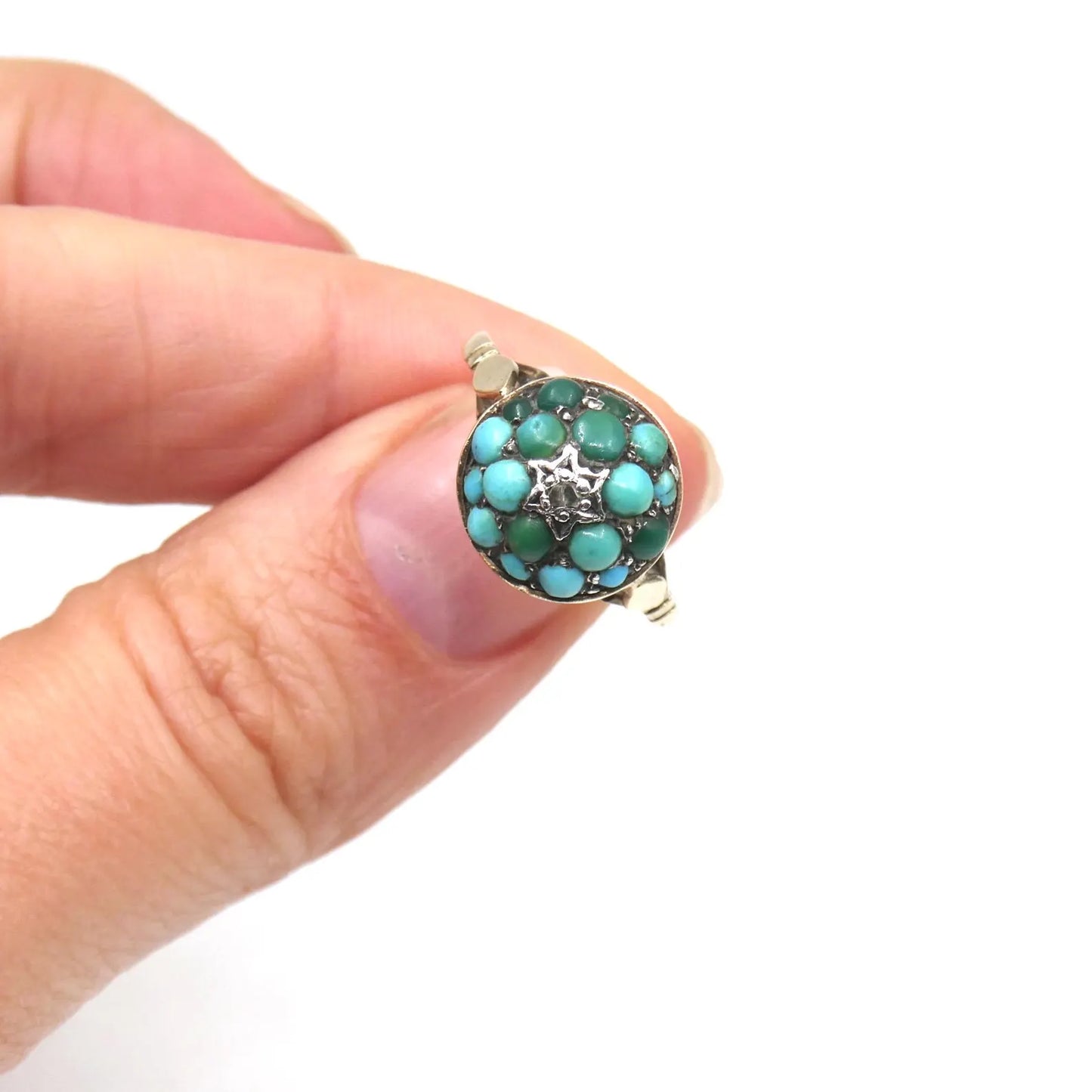 An antique turquoise bombe ring set with a star in the centre with a little diamond.