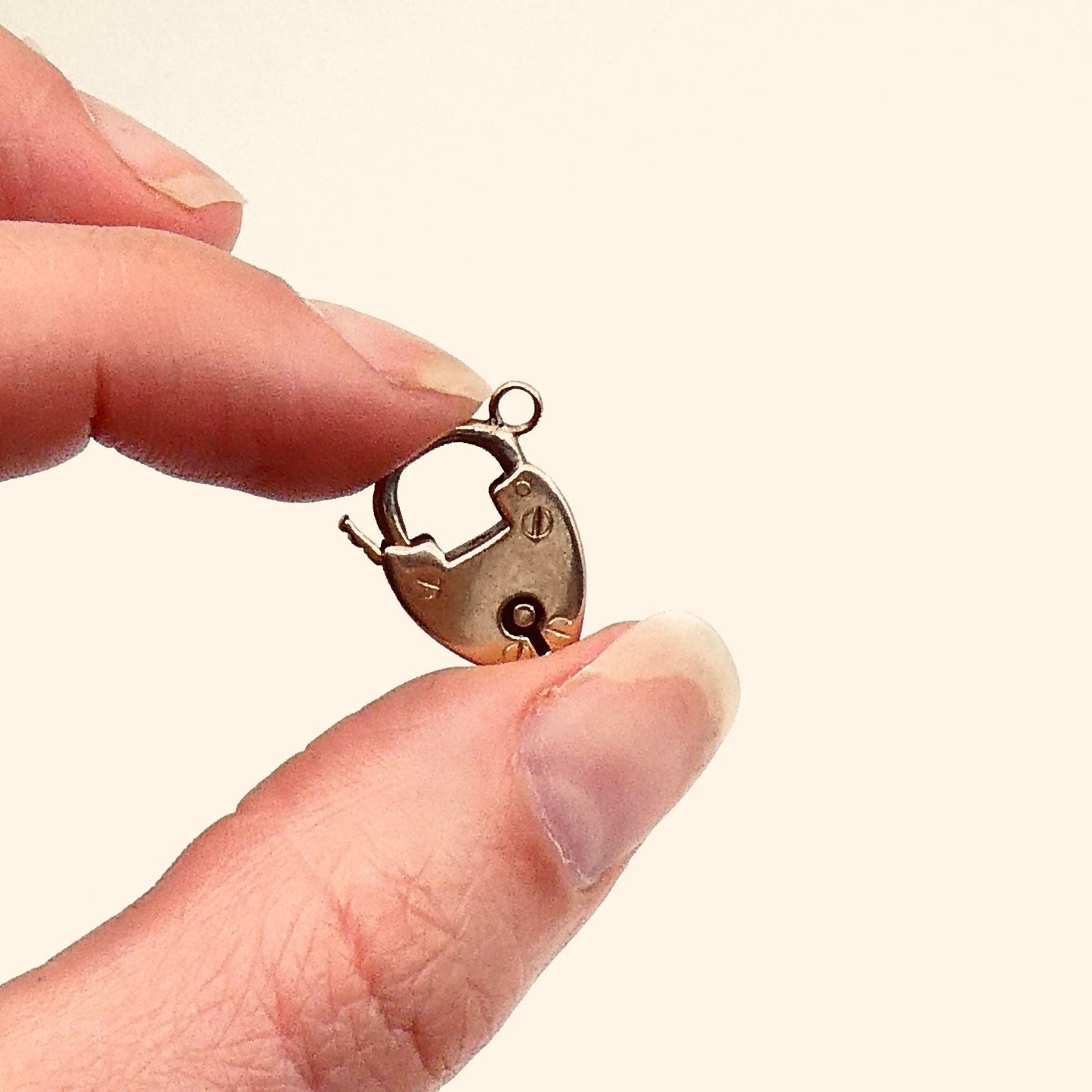 A small vintage 9kt gold padlock with rivets and a ring to hang on a chain, a rose gold toned padlock. - Collected