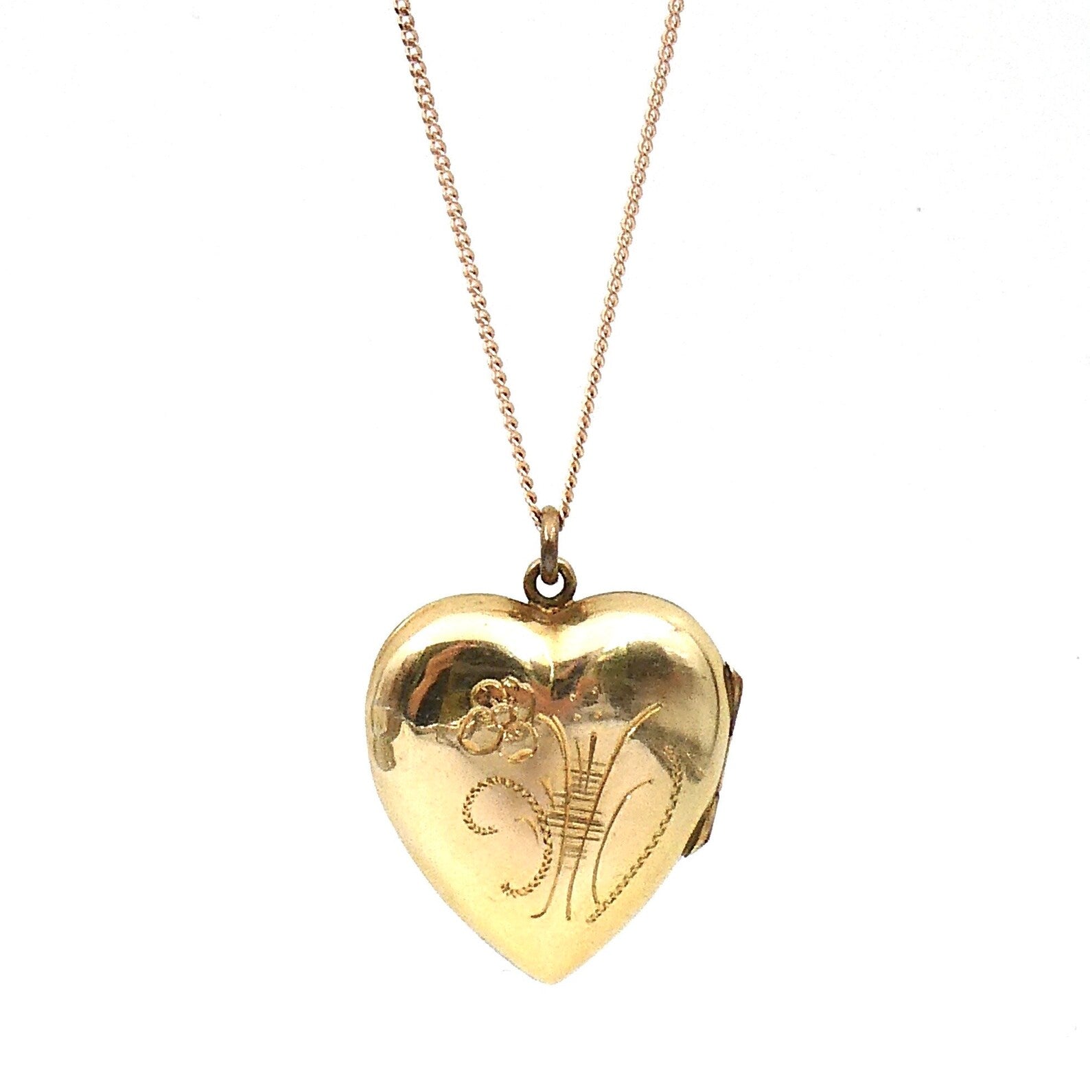A vintage heart locket that opens to the side, with a foliate spray etched on the front. - Collected