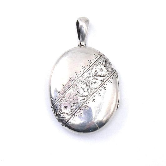 Engraved vintage locket, large oval silver locket with floral and leaf engraving diagonally across the locket. - Collected